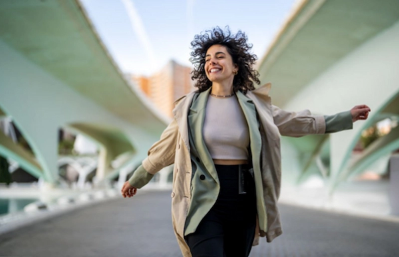 Mujer caminando sonriente por la ciudad tras formarse como especialista en igualdad de género
