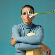 Curso de programación neurolingüística PNL: mujer sentada con flor a la altura de los ojos simula nueva perspectiva